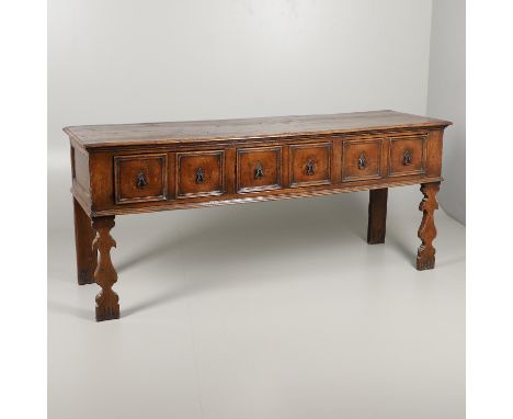 the two plank top above three twin-panelled drawers with iron handles and carved uprights, height 88cm, width 202cm, depth 62