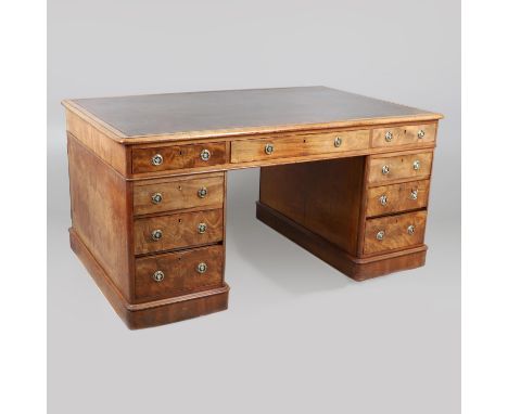 the gilt tooled leather inset top over an arrangement of nine drawers and three opposing drawers and cupboards, the drawer lo