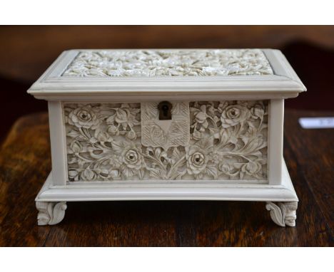 A Cantonese ivory rectangular jewel casket, carved overall with panels of peonies, foliage and small flowers, hinged cover en