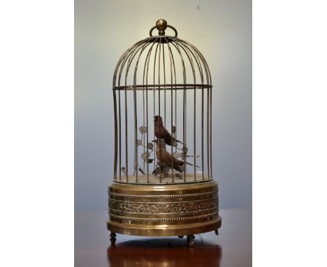 A clockwork musical automaton, as a pair of singing birds in a cage, loose ring finial, the base embossed with a band of flow