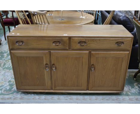 An Ercol sideboard, two long drawers over three door cupboard.