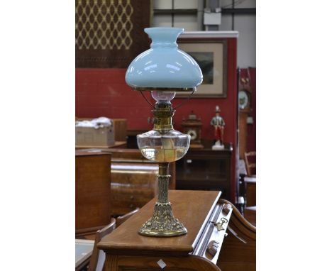 A Victorian oil lamp, clear glass reservoir, cast brass column, decorated with fruiting vines, pale blue shade Martin's Paten