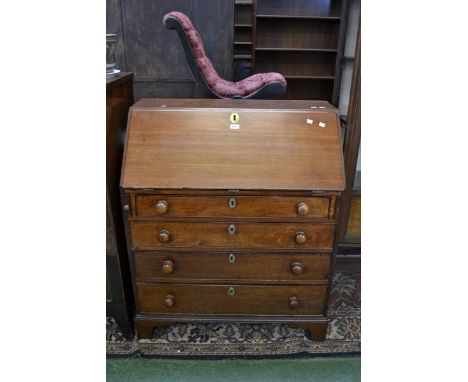 An oak bureau, fall front over four graduated drawers, button handles, ogee feet, late 19th century.