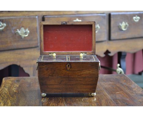 A George IV rosewood sarcophagus tea caddy, hinged cover enclosing a pair of lidded compartments, outlined throughout with bo