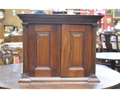 A Victorian mahogany collector's cabinet, dental cornice above a pair of locking field panelled doors opening to reveal a sli