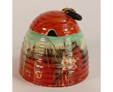 Clarice Cliff for Wilkinson, Beehive honey pot and cover in an orange ground floral design. a/f Height: 9.25cm