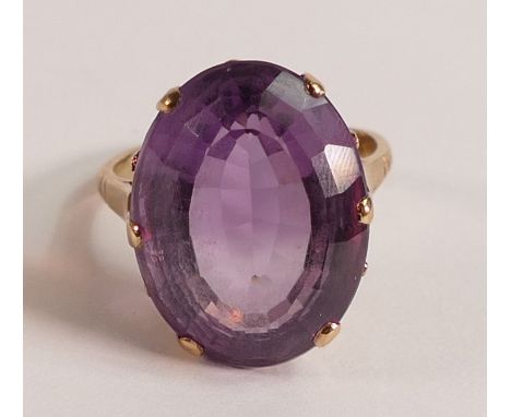 Yellow metal ladies dress ring set with large oval purple stone, tests to be 9ct gold, size M, 7g.