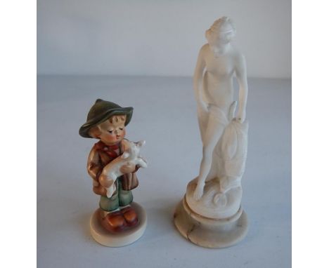 A Goebel Hummel figure of a shepherd boy, and a carved alabaster figure of a classical female nude figure, with marble socle,