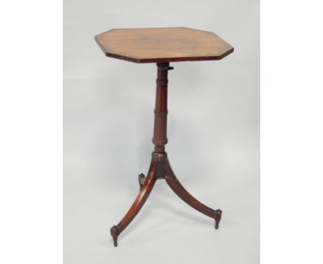 A George III mahogany adjustable tilt top tripod table, with octagonal crossbanded top supported on a tapered column with rin