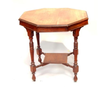 An Edwardian walnut octagonal table, upon four reeded and turned legs with cross stretcher and rectangular shelf.