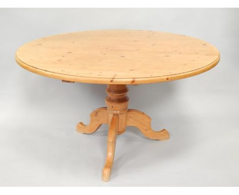 A circular pine dining table, with thumb moulded border supported on a turned tapering column and tripod base, 127cm dia.