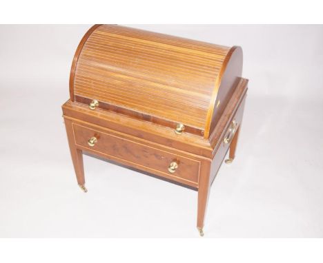 A yew veneered Georgian style sewing stand, with cylinder tamber shutter and hinged shelf to the interior, with a dummy drawe