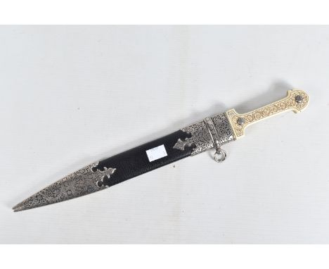 A DECORATIVE DAGGER WITH A CARVED HANDLE WITH EMBOSSED BLADE, this comes in a metal banded leather scabbard,We believe the da