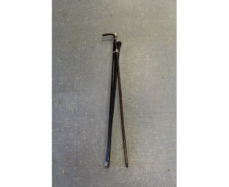 Two walking canes, one ebonised white metal top, other hard wood with knob handle, and lady's silver band walking stick