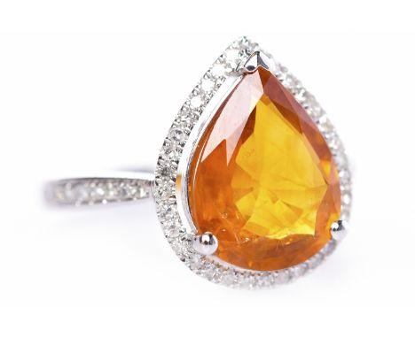 ORANGE SAPPHIRE AND DIAMOND RINGset with a pear shaped orange sapphire of approximately 2.63 carats surrounded by a halo of r