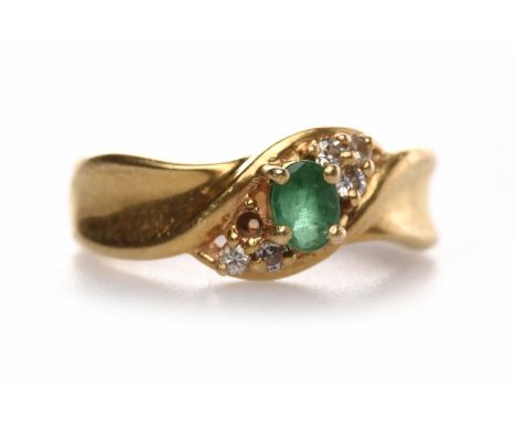 EIGHTEEN CARAT GOLD EMERALD AND DIAMOND RINGset with a central oval emerald 4.8mm flanked round diamonds, size M, 4.9g