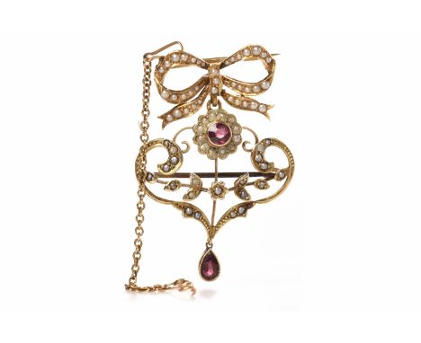 EDWARDIAN NINE CARAT GOLD BROOCH PENDANTof openwork form and set with seed pearls and two garnets, suspended from a fifteen c