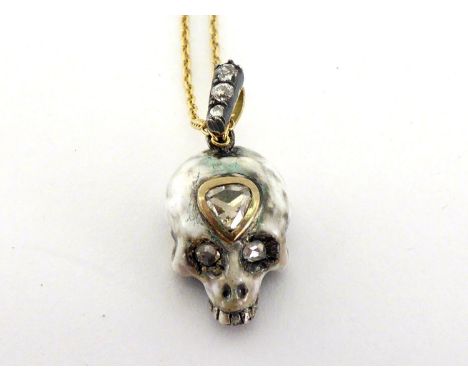 A diamond and enamel 'Third Eye' skull pendant by Gaetano Chiavetta, the white enamel skull with rub over set pear shaped ros