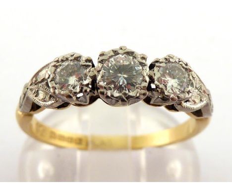 An 18 carat gold and three stone diamond ring, the three illusion set brilliants totalling approx. 0.31 carat, platinum set, 