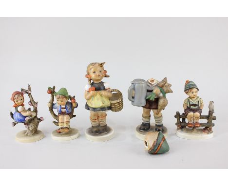 A collection of five Goebel Hummel porcelain figures including girl with a posy of flowers, 14cm, and two children sitting on