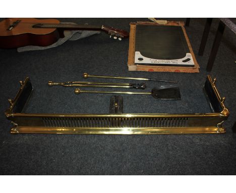 A brass fire fender, 94cm by 28cm, together with a set of fire tools, shovel, tongs and poker