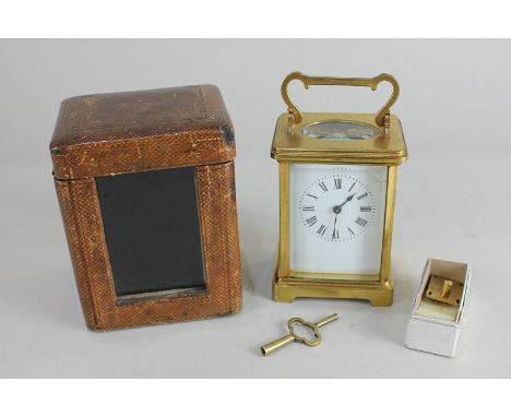 A gilt brass and bevelled glass cased carriage clock, the white enamel dial (a/f) with Roman numerals, with French movement (