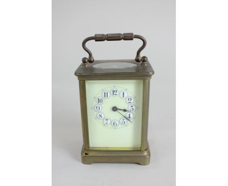 A brass and bevelled glass cased carriage clock with raised white enamel Arabic numerals on cream dial, 13.5cm high