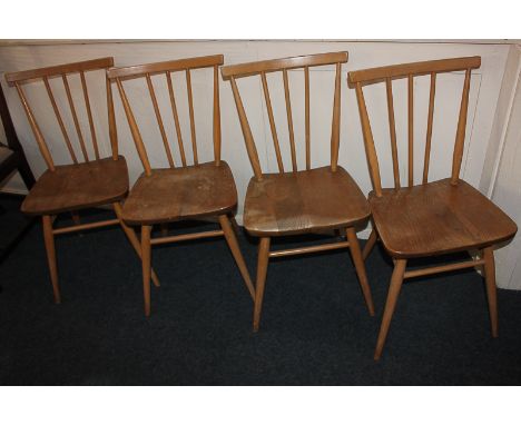 A set of four Ercol pale wood dining chairs with stick backs and solid seats