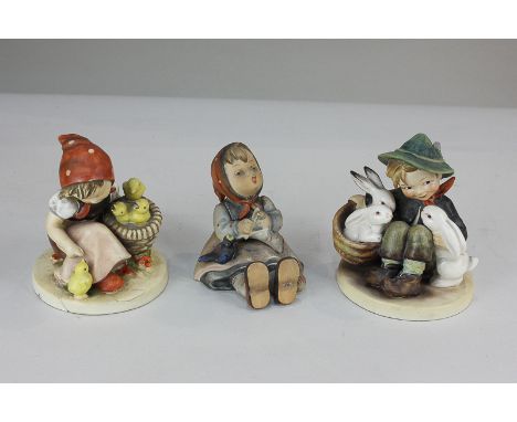 Three Goebel Hummel figures comprising boy with rabbits, girl with chicks, and girl knitting with blackbird, tallest 11cm, (t