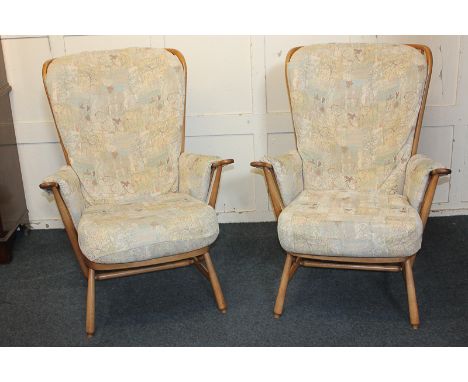 A pair of Ercol armchairs with stick backs, cushion seats and backs, with padded arms