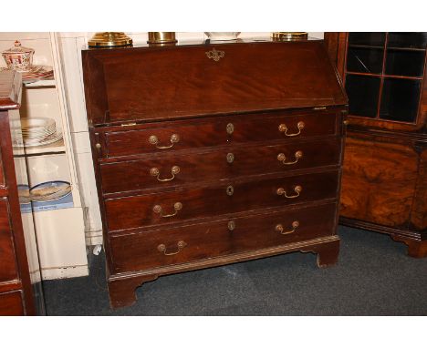 A George III mahogany bureau with fall front enclosing fitted interior of small drawers and pigeon holes, above four graduati