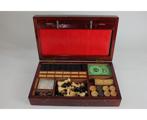 An early 20th century games compendium in mahogany box, comprising game boards, dominoes, whist, drafts, chess, dice, cards, 