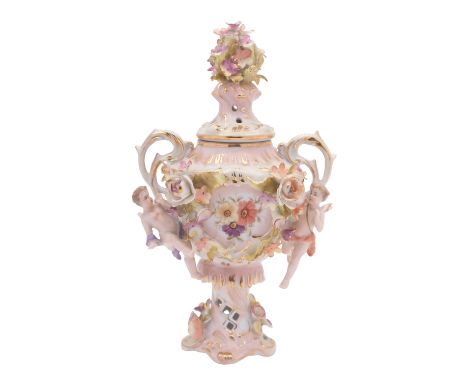 A Sitzendorf porcelain vase and cover, of footed two handled form with floral encrustation flanked by putti, under glaze blue