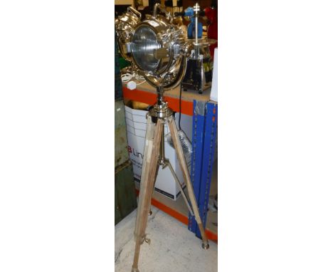 A polished metal search light type lamp on an adjustable tripod base.  Overall height 170cm CONDITION REPORTS A modern Indian