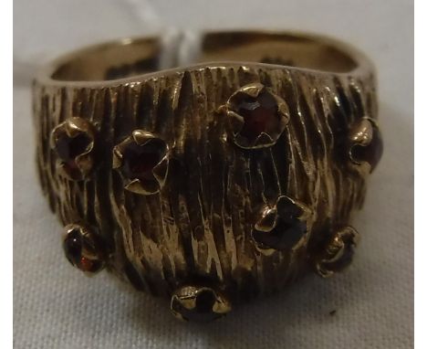 A 9 carat gold garnet set ring with textured bark decoration, size K, approx 5 g