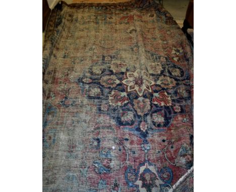 A Persian rug the central panel set with floral decorated medallion on a blue and red ground, within a stepped blue and red f