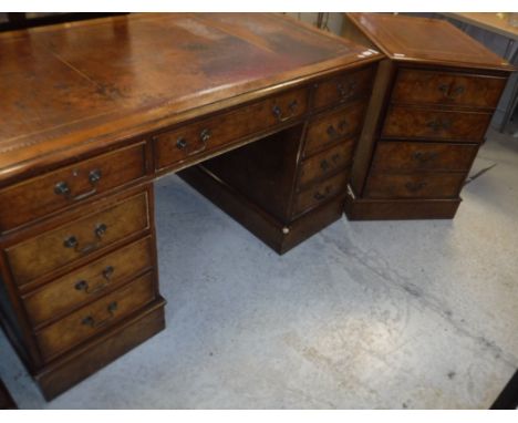 A modern burr walnut kneehole desk with tooled and gilded writing surface, the three frieze drawers raised on two banks of th