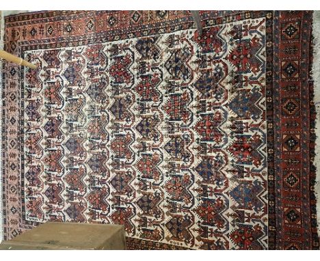 An Afsghar, the central panel set with repeating motifs on a cream ground, within a stepped blue and red geometric patterned 