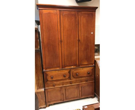 A Victorian mahogany housekeeper's cupboard three arch panel doors enclosing shelving over two four front compartments one wi