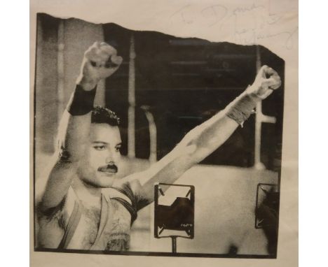 A photo montage of the band Queen comprising four magazine type portrait studies and a reproduction photo image of Freddie Me