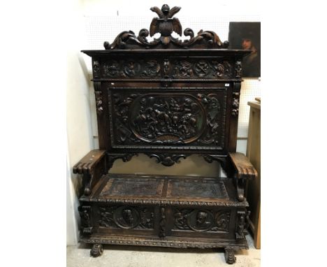 A carved painted and gilded walnut settle in the 17th Century Spanish taste the back with shield and twin headed eagle surmou