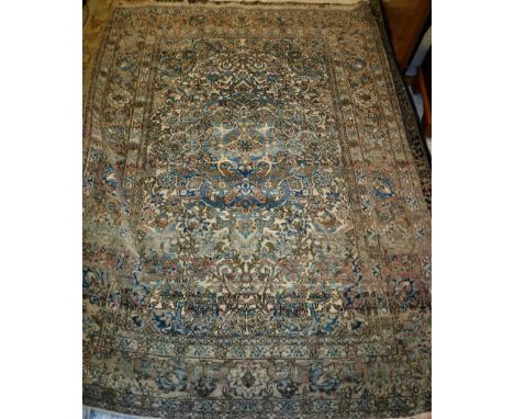 An Isfahan rug the central panel with all over floral decoration on a cream ground within a salmon pink, cream and blue flora