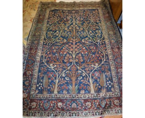 A Kashan rug, the central panel set with tree and foliate decoration on a blue ground within a stepped foliate decorated bord