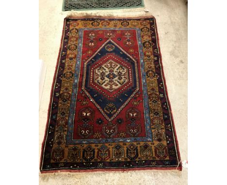 A Caucasian carpet, the central panel set with lozenge-shaped medallion on a red ground within a stepped blue, brown and red 