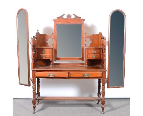 Victorian walnut triple wardrobe, shape pediment, central carved doors above drawers, flanked by mirrored doors, plinth base,