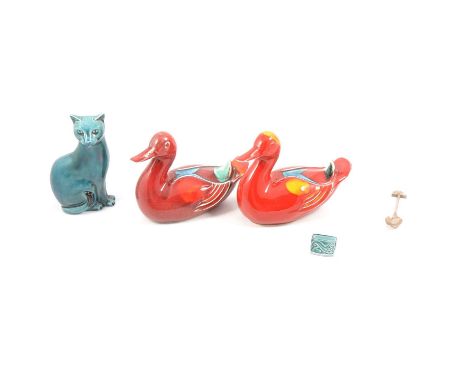 Six Poole Pottery dolphin figures; a cat; two Volcano pattern ducks; two daggers; a set of four Art Deco season plates; a Bea