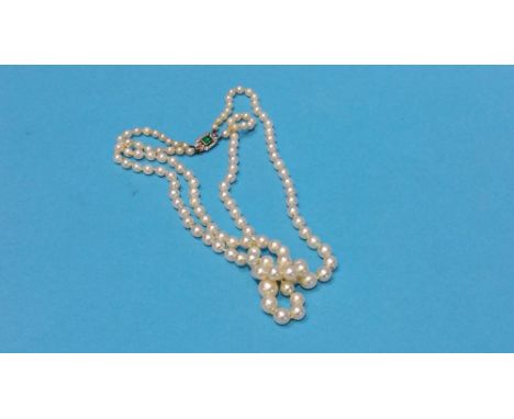 A pearl necklace tie clasp with baguette cut central emerald, approx. 40pts and surrounded by diamond chips
