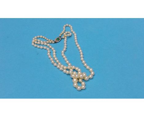 A pearl necklace tie clasp with baguette cut central emerald, approx. 40pts and surrounded by diamond chips