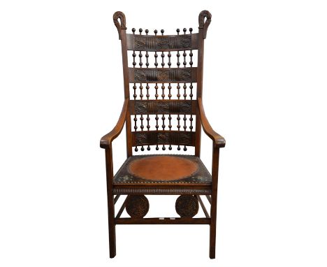 An Arts and Crafts chair, with curling swan neck finials, with openwork turned bobbin finials to foliate carved horizontal ba