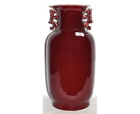 Chinese porcelain Sang de-boeuf vase of balaster shape with scroll handles, 50cm high
